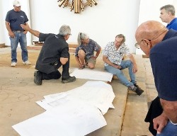 Architect David Huboi meets with contractors over plans for church altar.